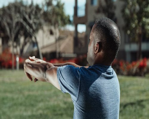 Man stretching outdoors in the late afternoon